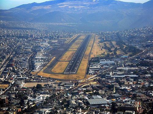Vista aérea de Quito con una pista de aeropuerto en el centro.
